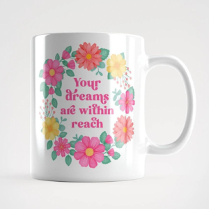 Motivational mug with quote: Your dreams are withing reach. Pink text with yellow, pink and orange floral wreath with green leaves and foliage.