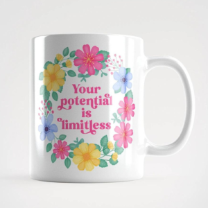 Motivational mug with quote: Your potential is limitless. Pink text with blue, pink and yellow floral wreath with green leaves and foliage.
