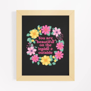 Motivational wall art with pink and yellow floral wreath on black background with text: You are beautiful on the inside and outside.