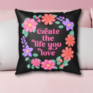 Motivational pillow with vibrant purple orange and pink flower wreath on black background with quote: Create the life you love