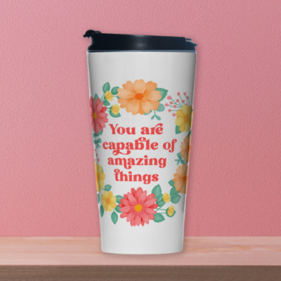 Motivational travel mug with yellow and orange floral wreath on white background with text: You are capable of amazing things.