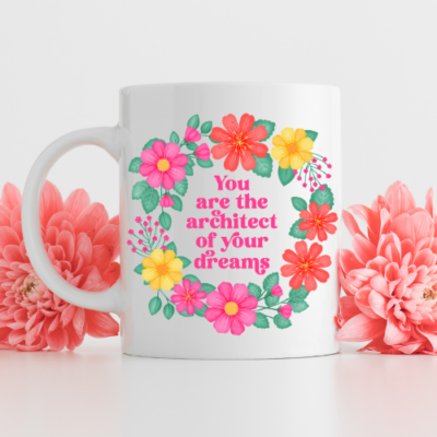 White motivational mug with vibrant floral wreath design and text reads: you are the architect of your dreams.