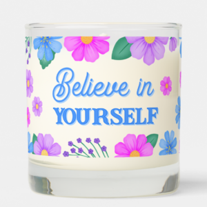 Inspirational candle with motivational quote: Believe in Yourself in script typography and purple, pink and blue flowers.