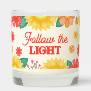 Inspirational candle with motivational quote: Follow the light in script typography and sunflowers with orange daisies and flowers.