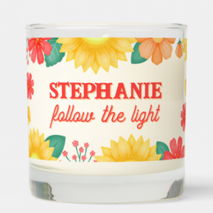 Personalized name gift candle with inspirational quote: Follow the Light and sunflowers with orange flowers and foliage and script typography.