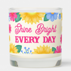 Inspirational candle with motivational quote: Shine bright every day in script typography and sunflowers with pink daisies and blue flowers.